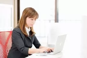 スーツ姿でパソコン操作するオフィスレディー。