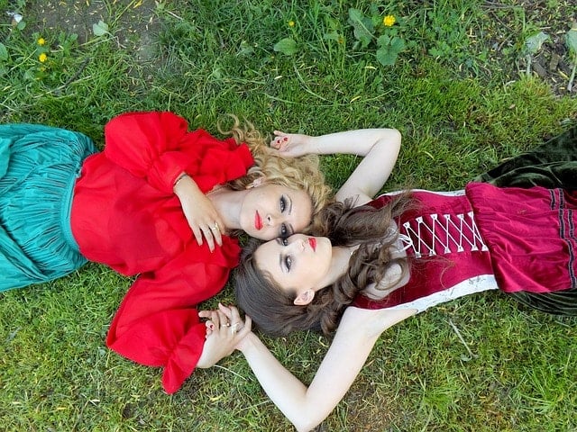 美女２人が芝生の上で寝転がっている。