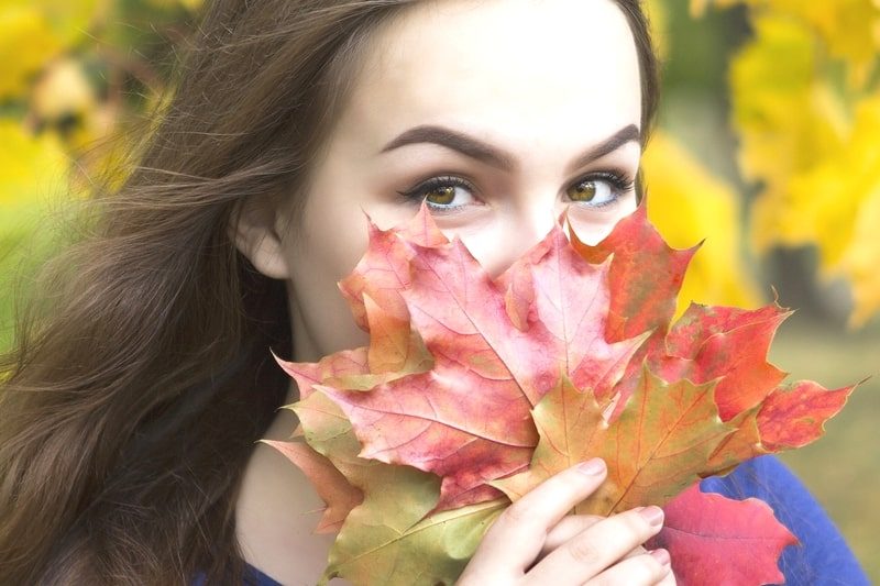 紅葉の紅葉で口を隠す美女。