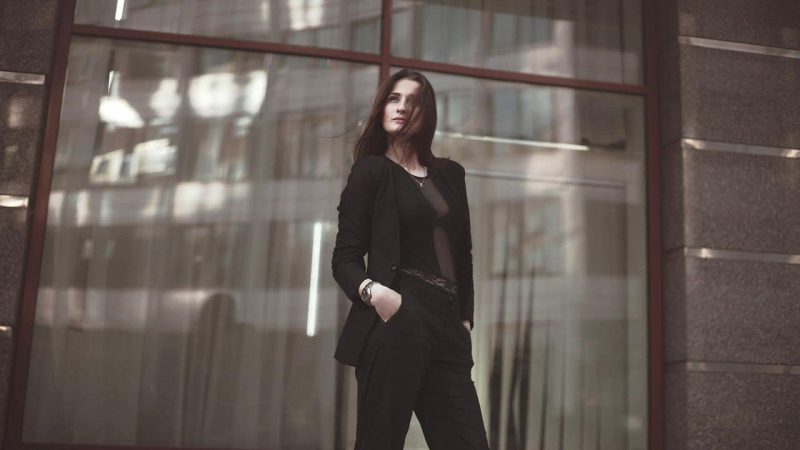 スーツを着た若い女性が上を見上げている。